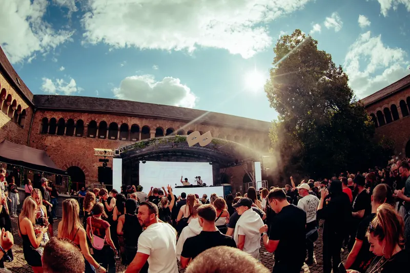 Portapulse 2026: Bühne und Publikum bei Sonnenschein im Brunnenhof